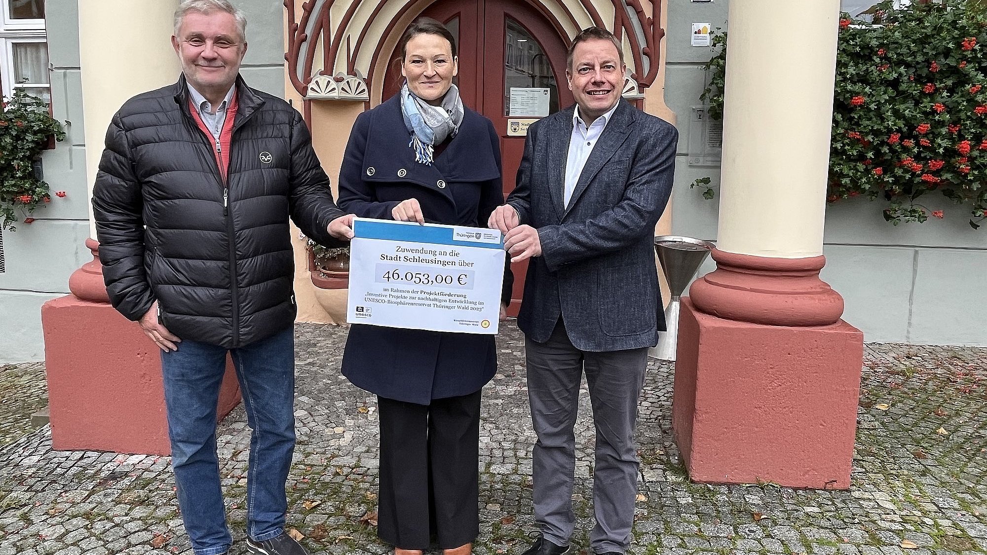 Drei Personen mit einem Förderscheck