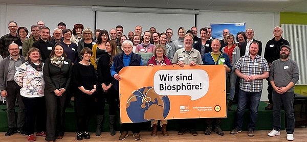 Gruppe mit Plakat Wir sind Biosphäre
