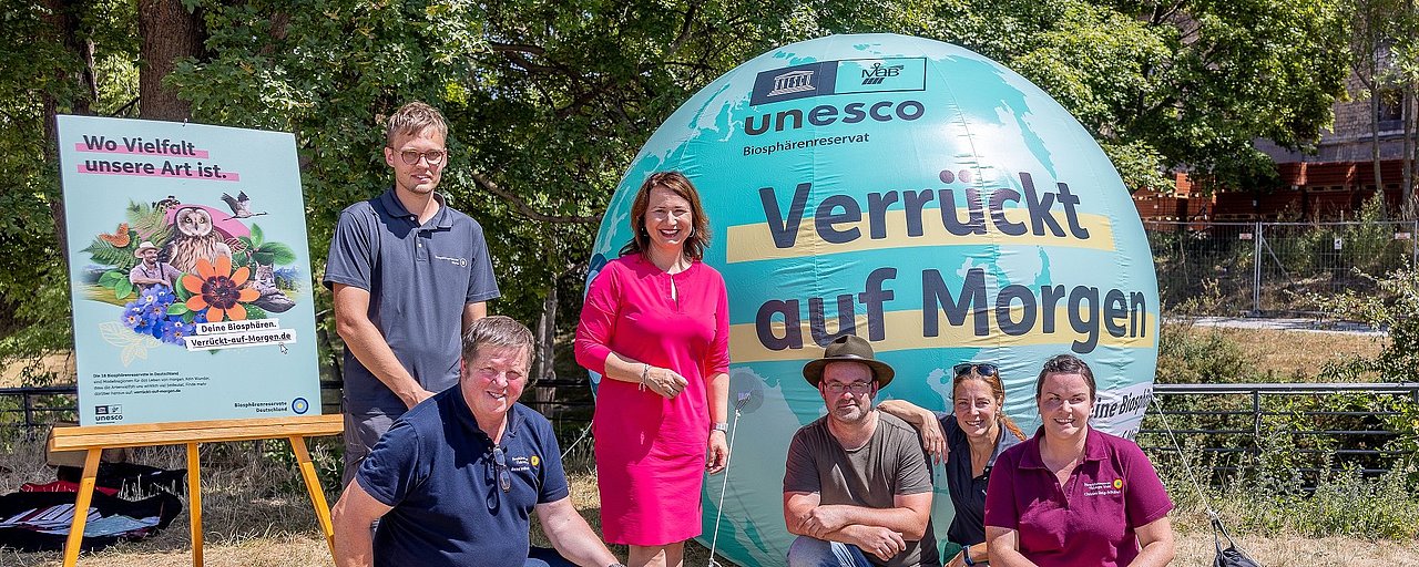Fünf Personen stehen vor einem aufgeblasenem Ball. Auf dem Ball steht Verrückt auf Morgen. Die Thüringer Umweltministerin informiert sich über die Werbekampagne.
