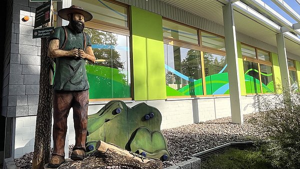 Holzfigur vor Haus