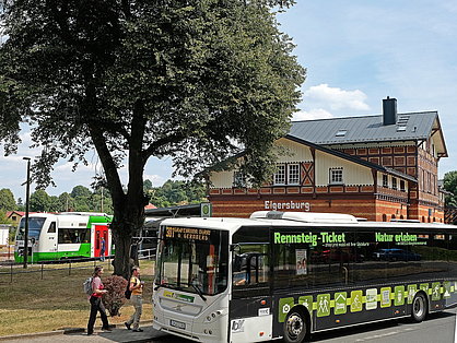 Linienbus mit RennsteigTicket-Aufdruck vor Bahnhofsgebäude