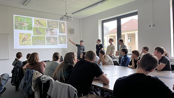 Gruppe hört einem Vortrag zur Vogelbeobachtung zu